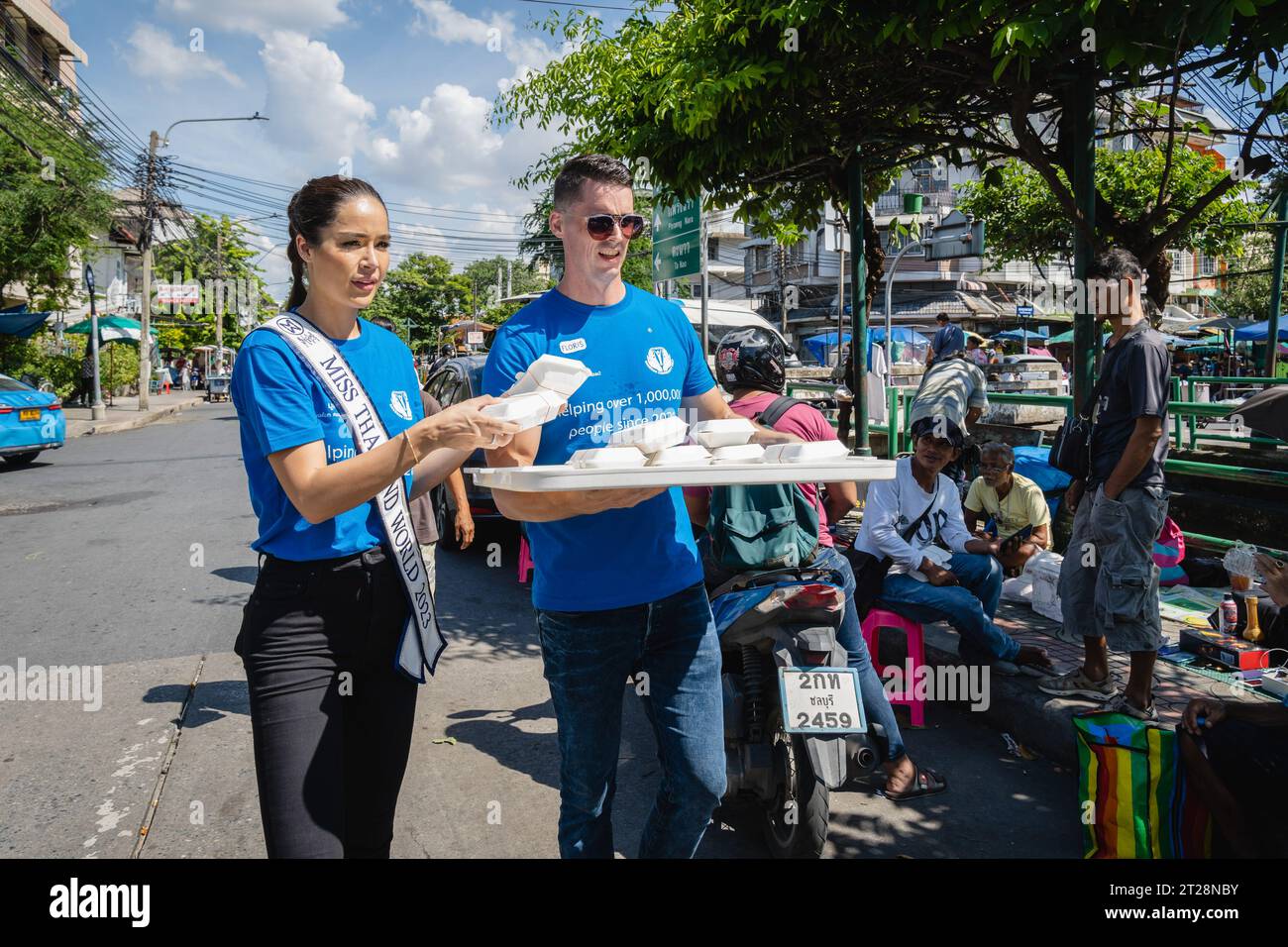 Bangkok, Thailandia. 14 ottobre 2023. Miss Thailand World 2023, Tharina Botes distribuisce gratuitamente scatole di cibo con un volontario della Bangkok Community Help Foundation, presso la Trok Sake Community di Bangkok. Miss Thailand World 2023, Tharina Botes, patrimonio misto thailandese-sudafricano, si unì come volontario a una dispensa di pasti gratuiti per senzatetto e persone a basso reddito, organizzata dalla Bangkok Community Help Foundation, a Bangkok, Thailandia. (Foto di Nathalie Jamois/SOPA Images/Sipa USA) credito: SIPA USA/Alamy Live News Foto Stock