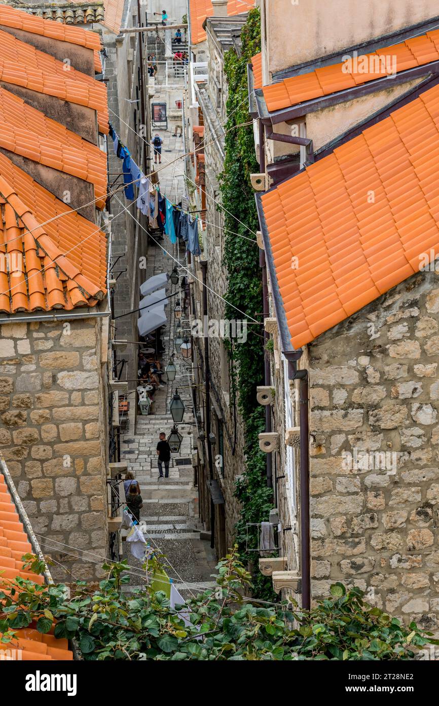 Vista dalla passeggiata delle mura della città di un vicolo nella città vecchia di Dubrovnik, nella Croazia meridionale. Foto Stock