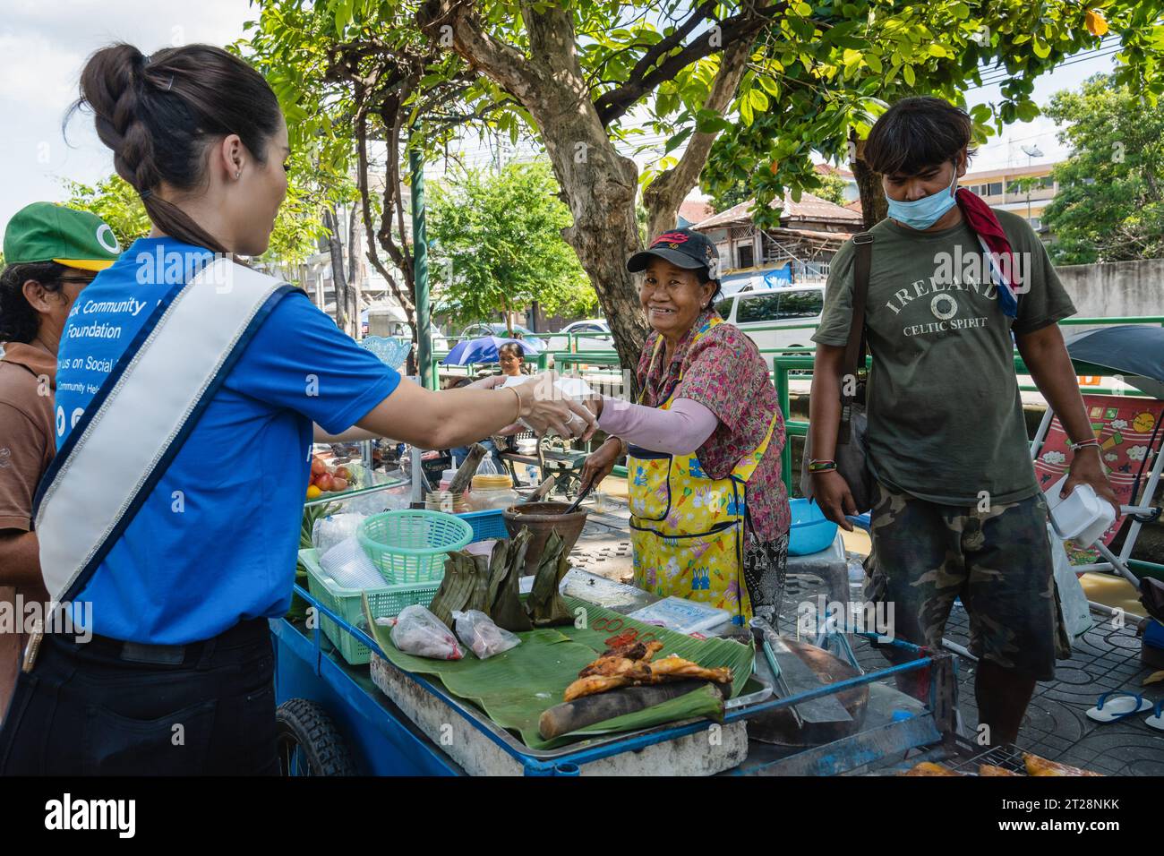 Bangkok, Thailandia. 14 ottobre 2023. Miss Thailand World 2023, Tharina Botes distribuisce pasti gratuiti a un venditore a basso reddito con la fondazione Bangkok Community Help, presso la comunità Trok Sake di Bangkok. Miss Thailand World 2023, Tharina Botes, patrimonio misto thailandese-sudafricano, si unì come volontario a una dispensa di pasti gratuiti per senzatetto e persone a basso reddito, organizzata dalla Bangkok Community Help Foundation, a Bangkok, Thailandia. (Immagine di credito: © Nathalie Jamois/SOPA Images via ZUMA Press Wire) SOLO USO EDITORIALE! Non per USO commerciale! Foto Stock