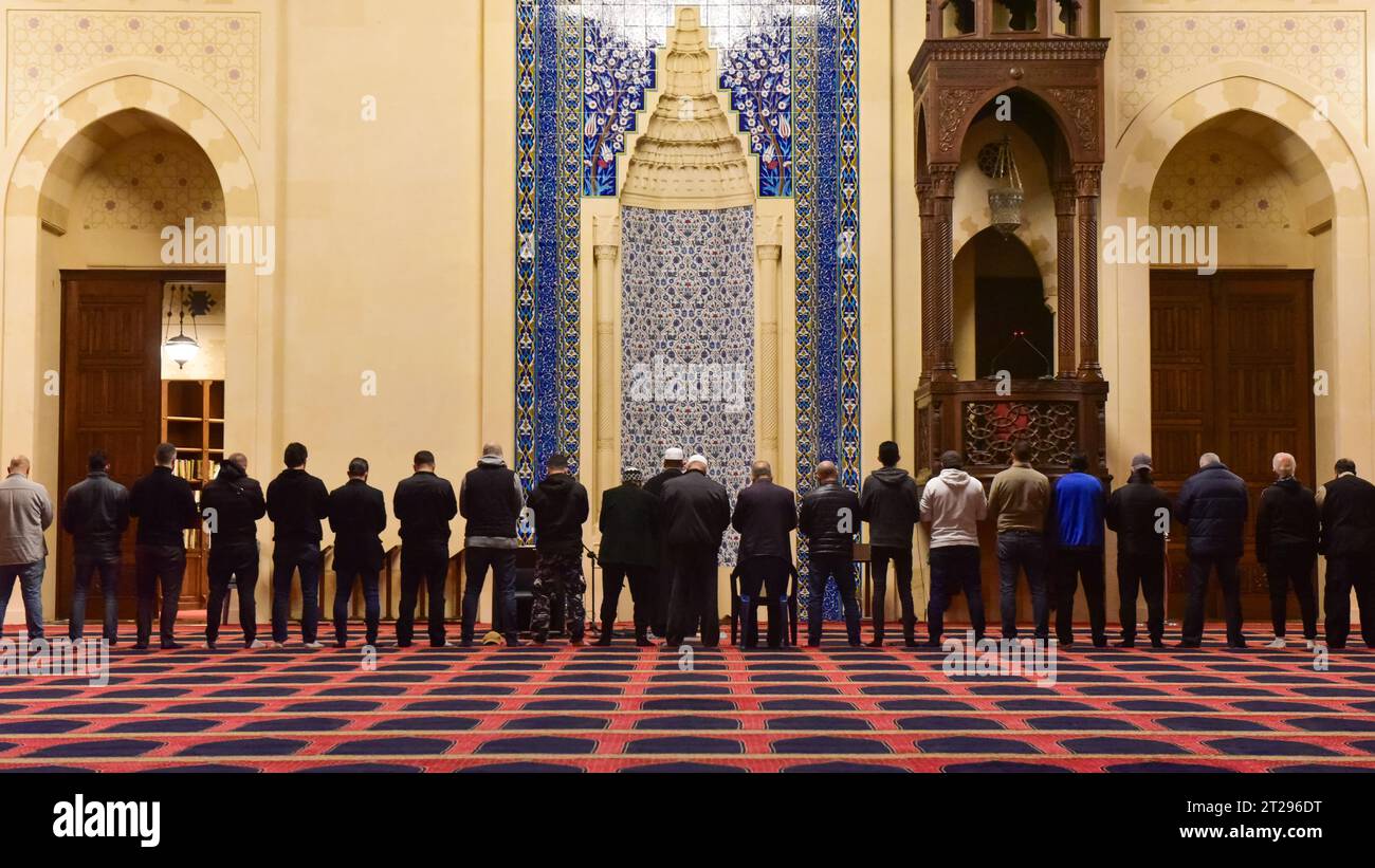 Musulmani maschi che fanno le loro preghiere del Maghrib (sera) di fronte al mihrab/direzione della Mecca nella Moschea Mohammad al Amin, Beirut, Libano Foto Stock