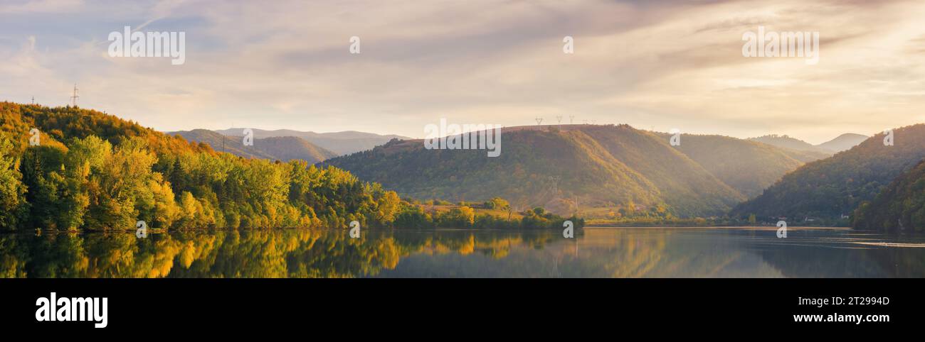 paesaggio di campagna montuoso al tramonto. panorama di uno splendido paesaggio naturale con un lago sotto un cielo mozzafiato alla luce della sera Foto Stock