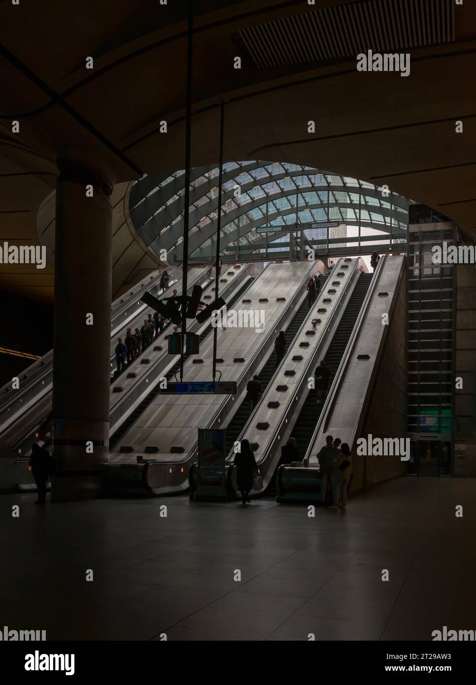 Londra, Inghilterra - 16 ottobre 2023 - persone in sella alle scale mobili all'interno della stazione della metropolitana di Canary Wharf. È una stazione sulla Jubilee Line Foto Stock