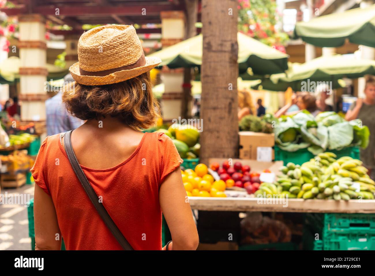 Un turista che indossa un cappello al mercato agricolo nella città di Funchal a Madeira. Portogallo Foto Stock