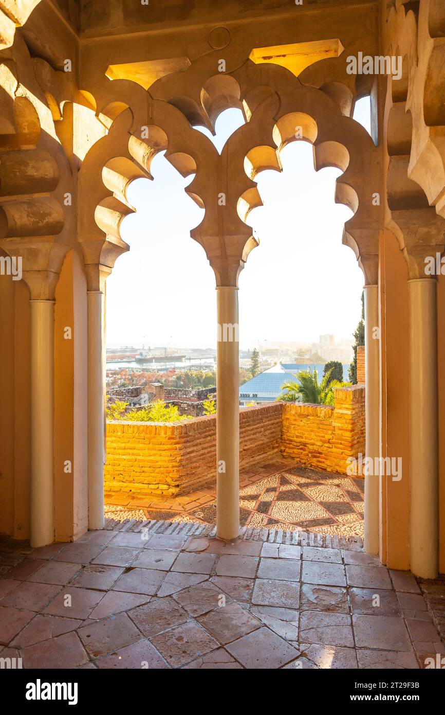 Guarda il tramonto dalle porte arabe di un cortile dell'Alcazaba nella città di Malaga, Andalusia. Spagna. Fortezza medievale in stile arabo Foto Stock