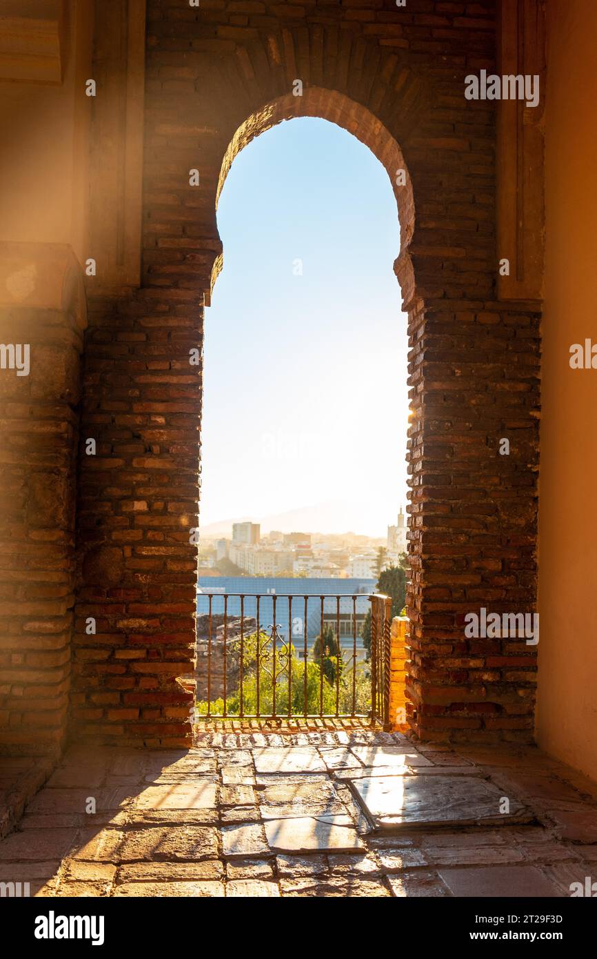 Tramonto dalle porte arabe di un cortile dell'Alcazaba nella città di Malaga, Andalusia. Spagna. Fortezza medievale in stile arabo Foto Stock