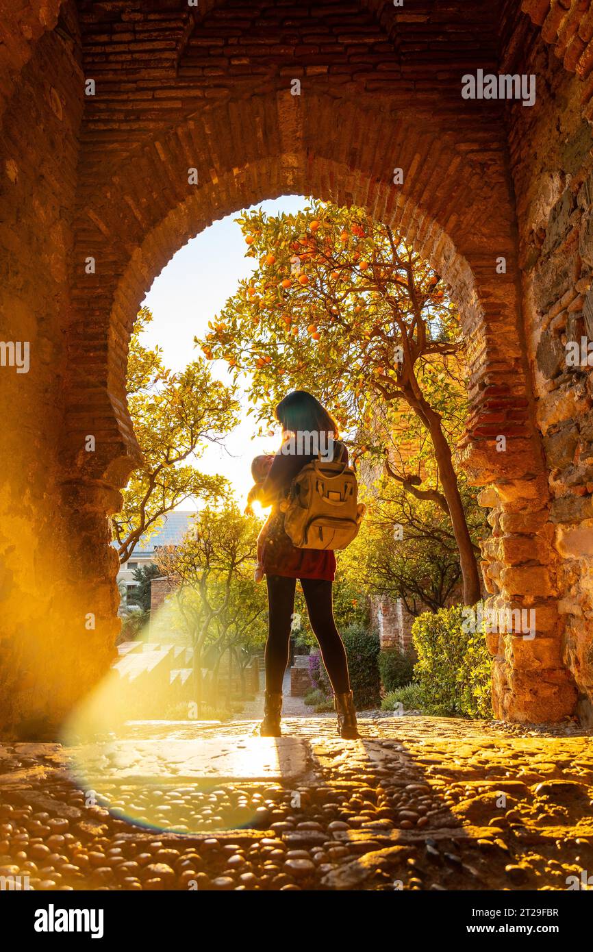 Una turista con suo figlio al tramonto alla porta delle mura dell'Alcazaba nella città di Malaga, Andalusia. Spagna. Fortezza medievale in stile arabo Foto Stock