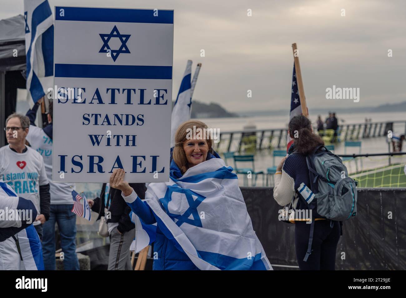 Seattle, Stati Uniti. 17 ottobre 2023. Un partecipante tiene un cartello con la scritta "Seattle Stand with Israel" durante la manifestazione. Oltre un centinaio di manifestanti si sono riuniti al Pier 62 di Seattle per accendere le candele e pregare per coloro che sono stati colpiti dal conflitto in corso in Israele. I raduni, caratterizzati da un senso di unità ed empatia, durarono un'ora, inviando un messaggio di speranza e solidarietà. Credito: SOPA Images Limited/Alamy Live News Foto Stock