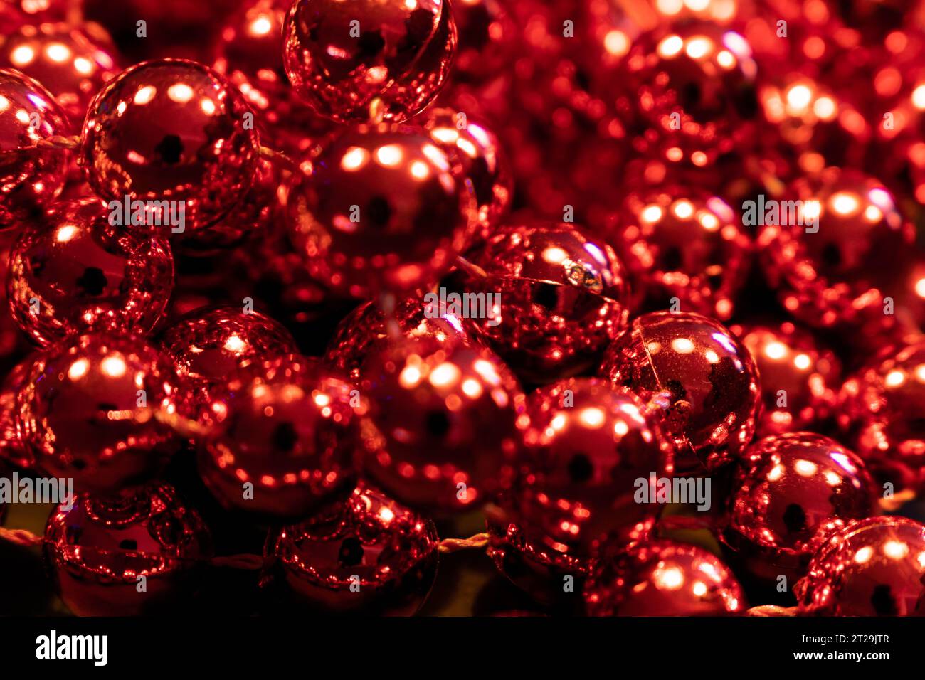 Palline rosse metalliche. Decorazione natalizia garland. Primo piano. Messa a fuoco selettiva Foto Stock