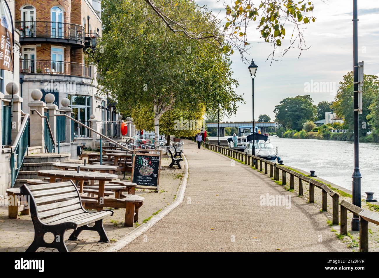 Una vista sul Tamigi a Staines-upon-Thames oltre lo Slug e il pub di lattuga con tavoli e panchine all'esterno. Foto Stock