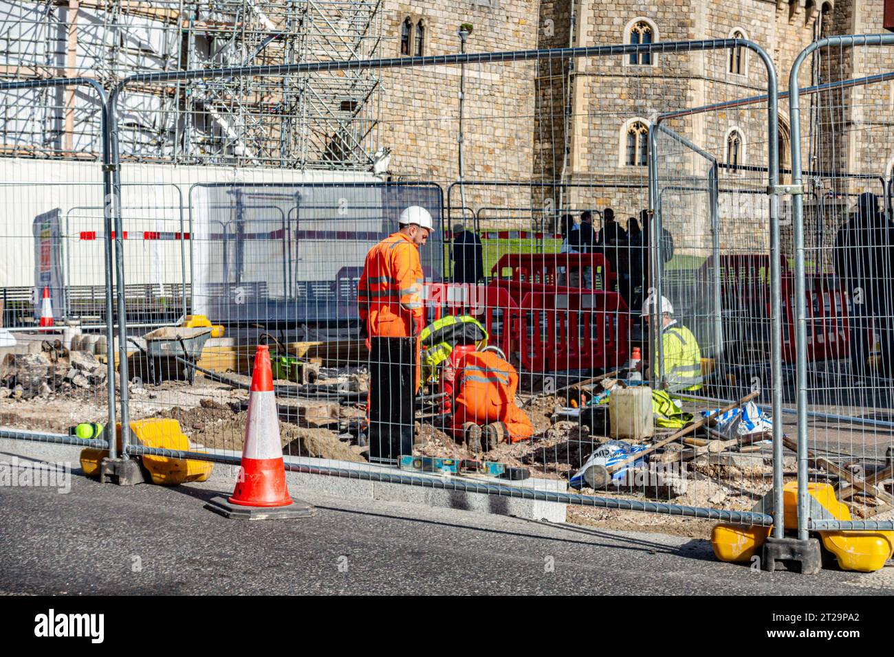 Lavori stradali all'esterno del Castello di Windsor intorno alla statua di bronzo della Regina Vittoria. L'area è recintata mentre gli operai scavano la strada. Foto Stock