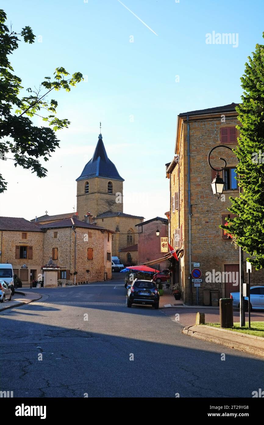 La strada principale del villaggio di Bagnols, l'ufficio postale e la torre della chiesa nella campagna delle pietre dorate - Pierre Dorées, regione francese Foto Stock