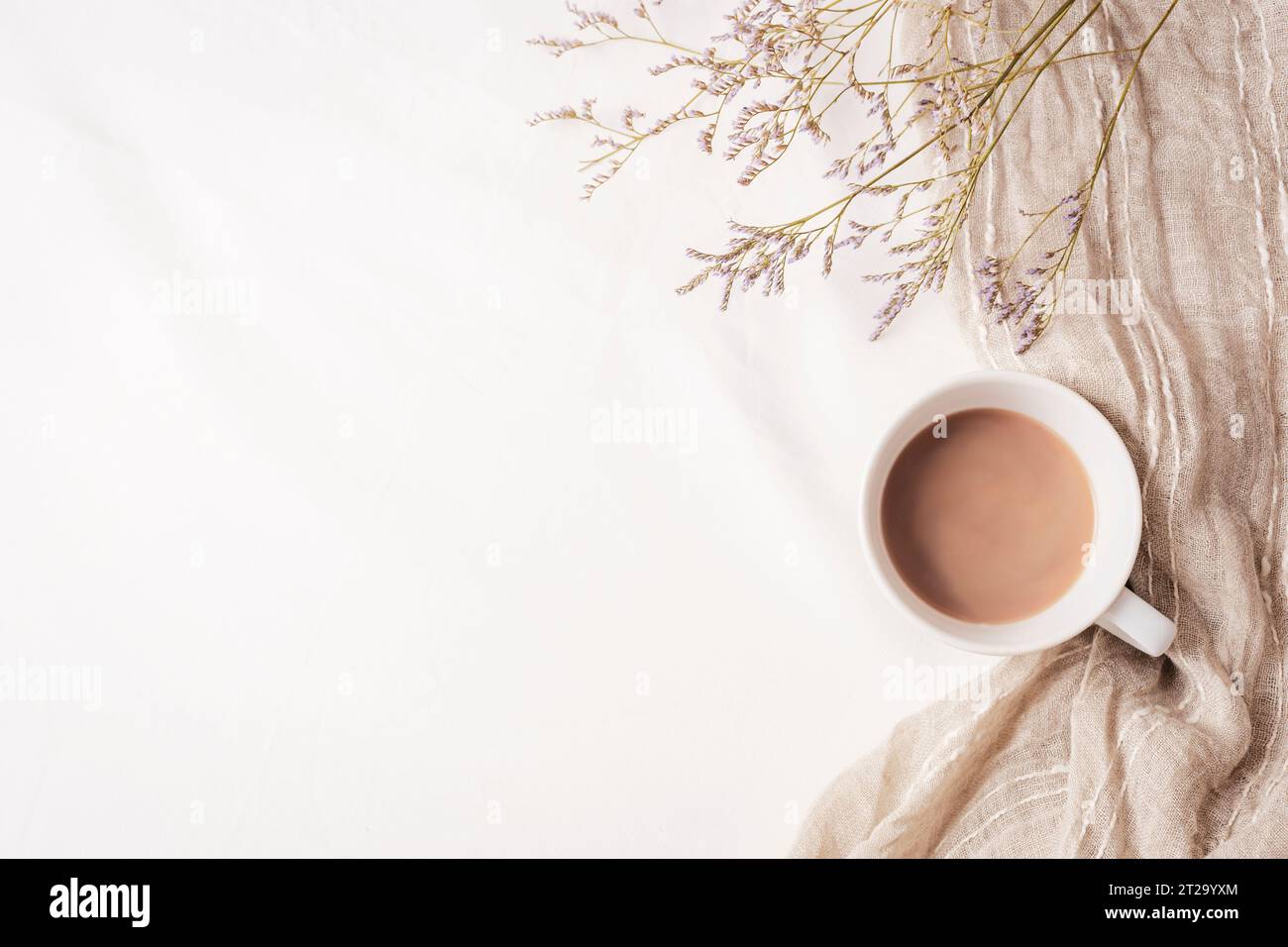 Tazza di caffè, tovagliolo e fiori piccoli su lino bianco. Casa accogliente, colazione, comfort, concetto hygge. Vista dall'alto, base piatta, spazio di copia. Foto Stock