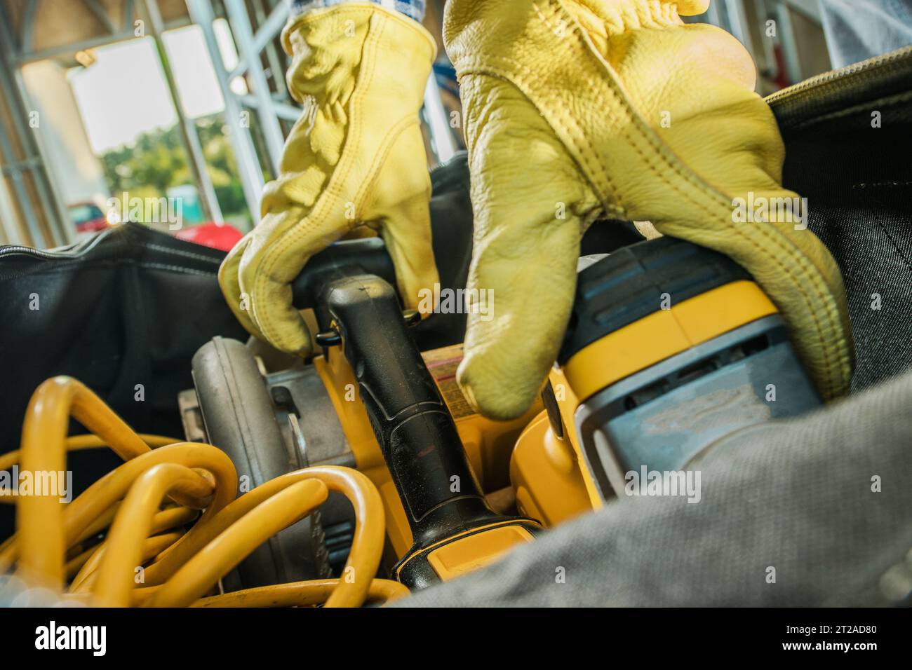Appaltatore edile che afferra gli utensili elettrici dalla borsa delle attrezzature in primo piano. Foto Stock