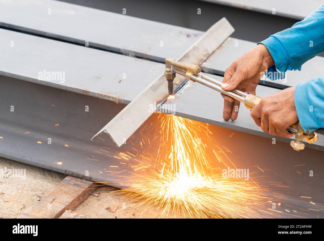 Saldatrice che utilizza una torcia da taglio ossiacetilene in cantiere. Foto Stock