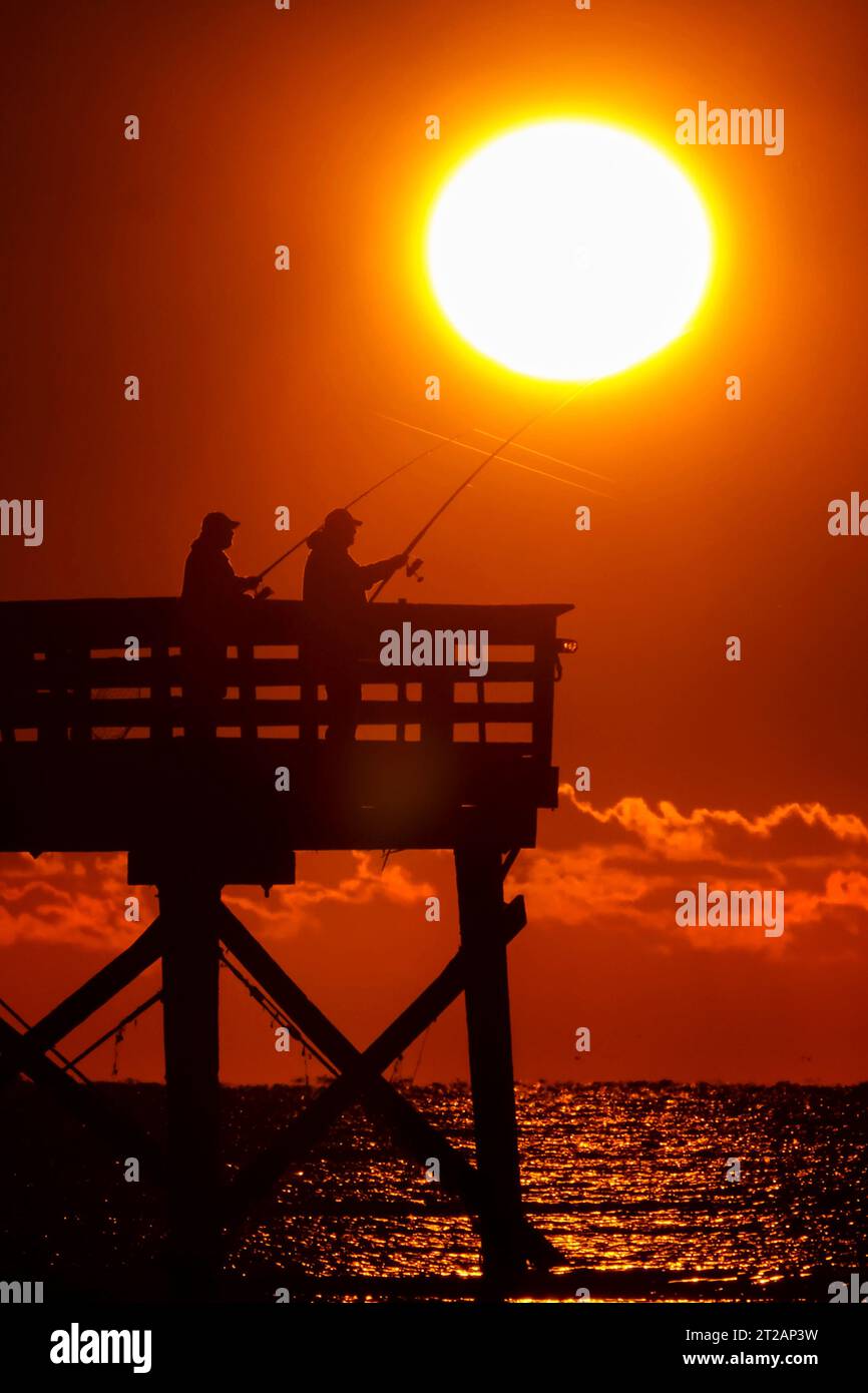 Isola di Palms, Stati Uniti. 17 ottobre 2023. Fisherman sagomato dall'alba tenta la fortuna dal molo Isle of Palms, il 17 ottobre 2023 a Isle of Palms, South Carolina. Crediti: Richard Ellis/Richard Ellis/Alamy Live News Foto Stock