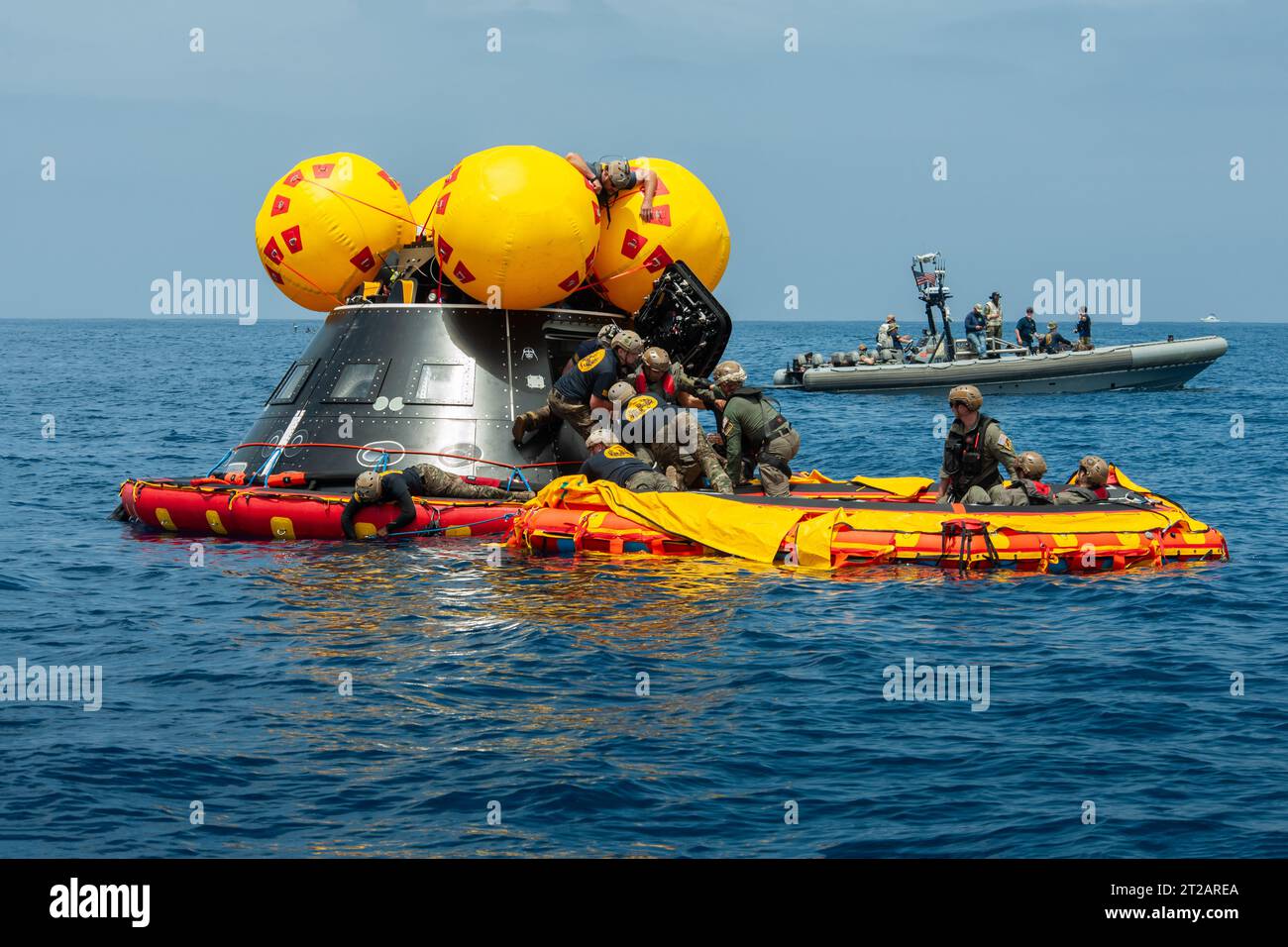 Artemis II Orion in corso Recovery test 10 (URT-10) - Day 5. Il personale della NASA, della Marina e dell'Aeronautica pratica le procedure di recupero Artemis nell'Oceano Pacifico come parte del test di recupero in corso 10 (URT-10) al largo della costa di San Diego. In questa foto, i sommozzatori della Marina sono visti entrare nell'articolo di prova del modulo dell'equipaggio Orion (CMTA) e assistere un membro dell'equipaggio simulato che esce dalla navicella spaziale per esercitarsi a recuperare gli astronauti fuori dalla navicella spaziale e su un "portico anteriore" gonfiabile dove l'equipaggio sarà prelevato con elicotteri e sollevato via elicottero alla nave di recupero. Foto Stock