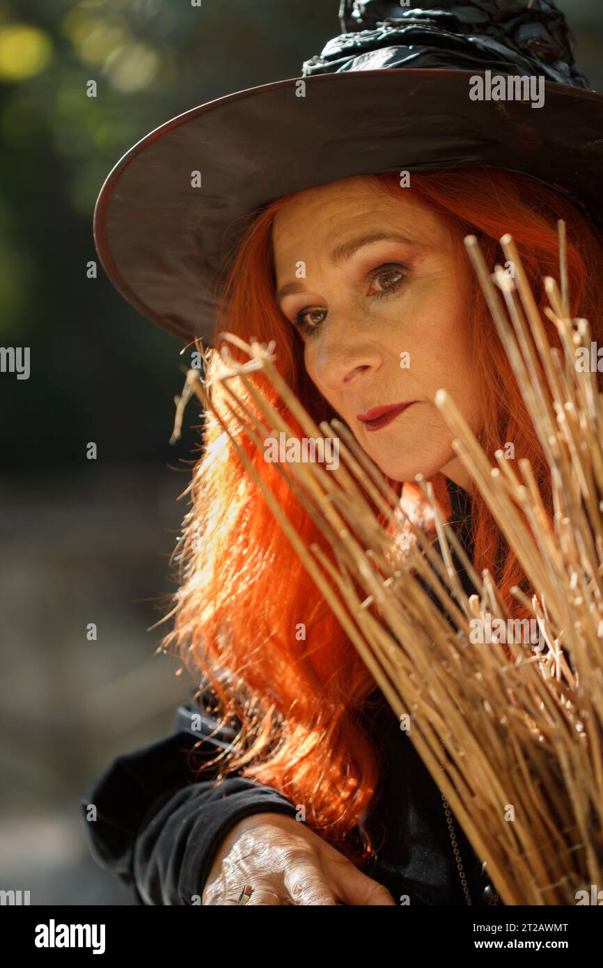Strega con scopa e look premuroso che prepara l'azione ad Halloween, El Preventorio de Alcoi, Spagna Foto Stock