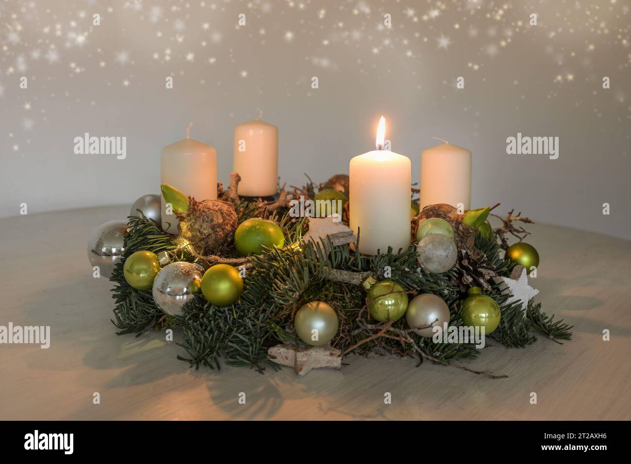 Primo Avvento, corona con una candela bianca bruciata e decorazione natalizia verde su un tavolo, arredamento per la prima domenica, spazio fotocopie, selezione di Foto Stock