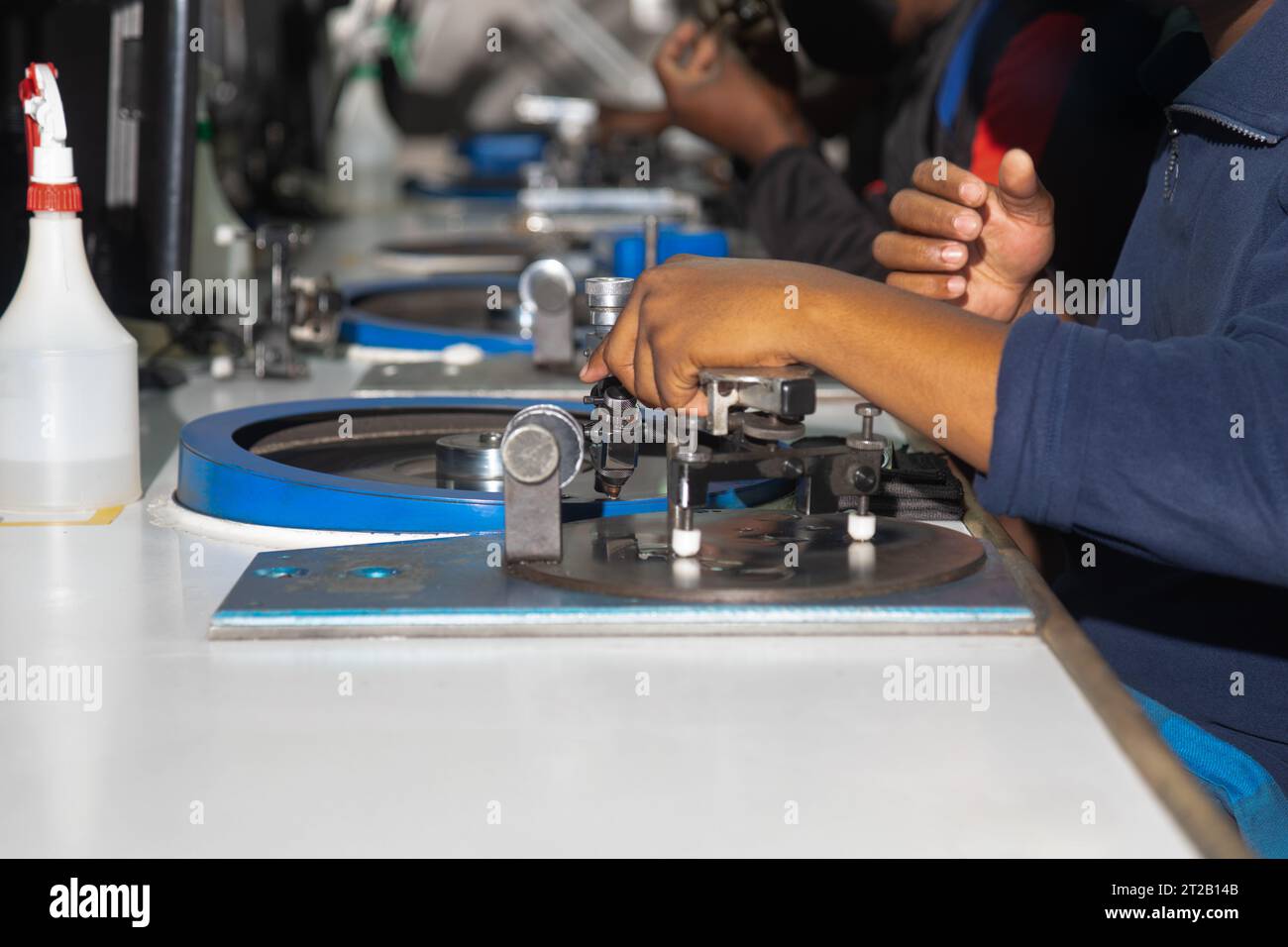 donna operaia africana che lucida un diamante in fabbrica alla ruota che gira Foto Stock