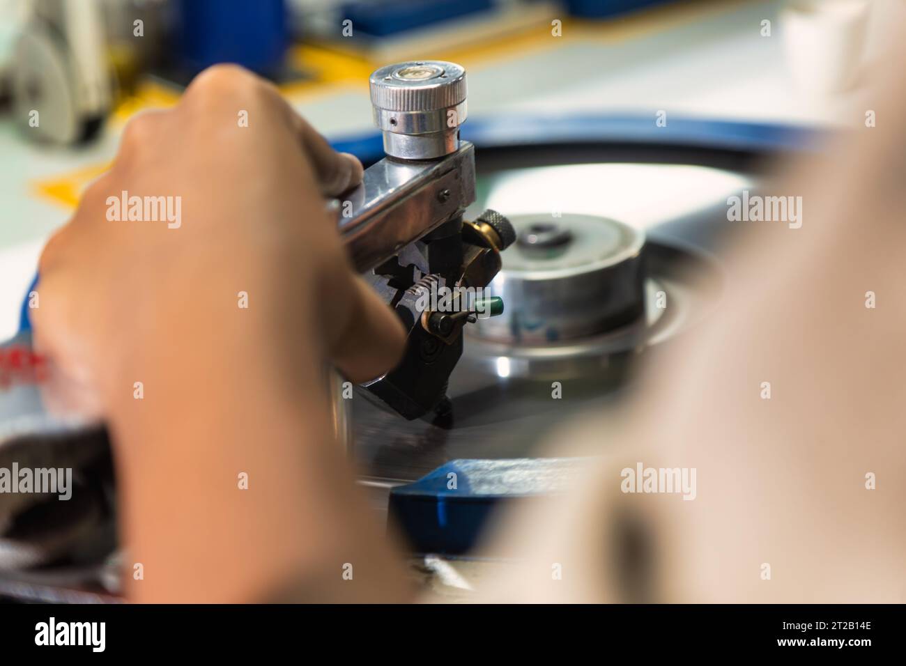mano di una lavoratrice africana che lucida un diamante nella fabbrica alla ruota che gira Foto Stock