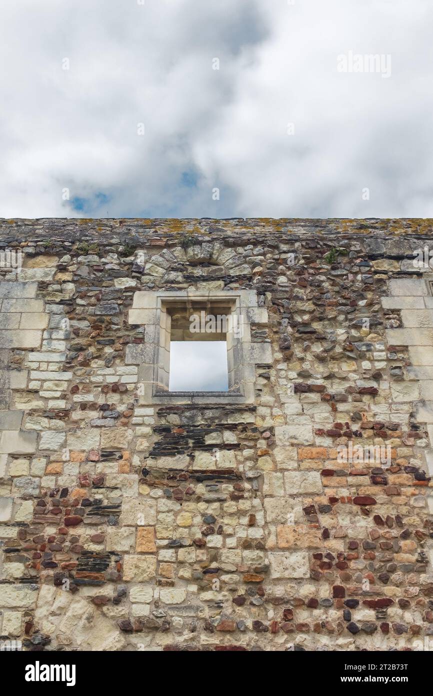 Angers, Francia, 2023. Una finestra che si apre su un cielo nuvoloso sull'ultima parete in piedi della grande sala medievale (X secolo) della Château d'Angers Foto Stock