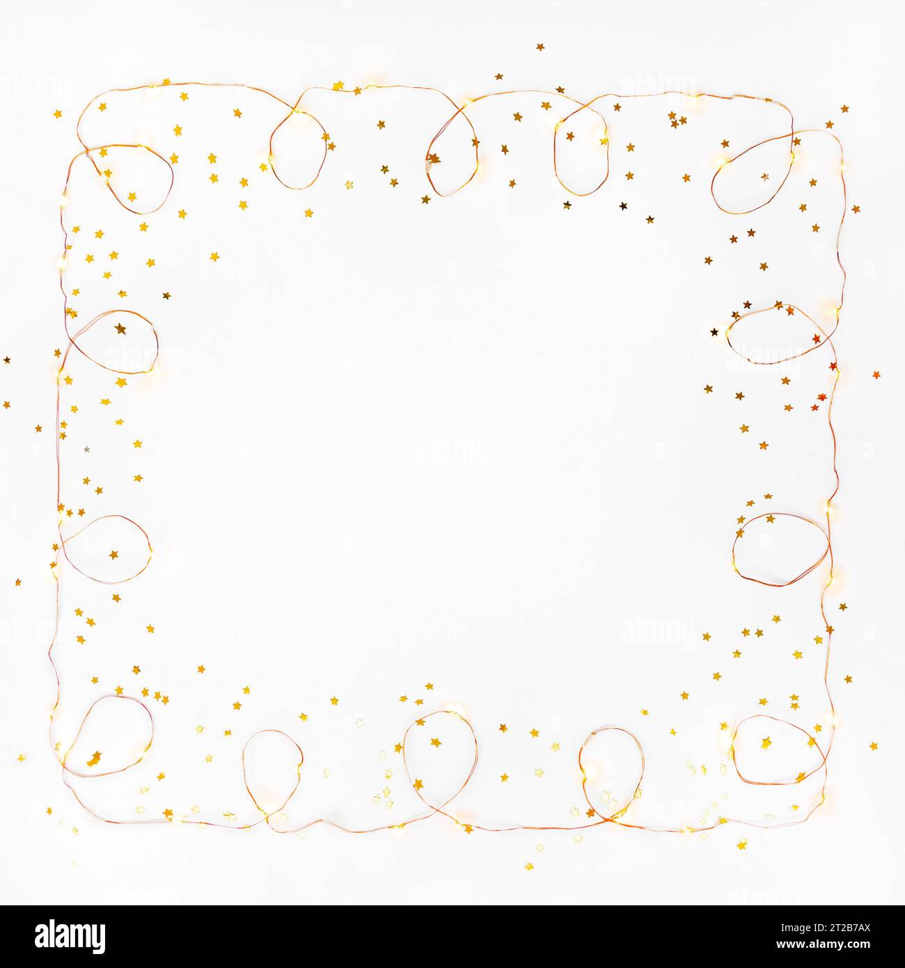 Square Christmas Lights garland Border e coriandoli con stelle dorate su sfondo bianco. Base piatta, spazio copia. Foto Stock