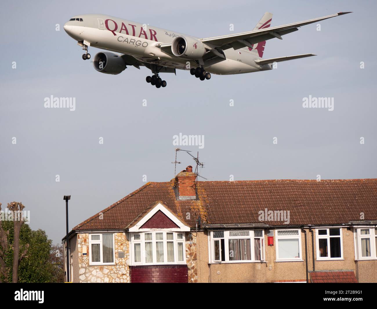 Aeroporto di Londra Heathrow Hounslow Qatar Cargo, gestito da Qatar Airways Boeing 777-FDZ Airways in avvicinamento all'atterraggio a bassa quota volando sopra abitazioni residenziali Foto Stock