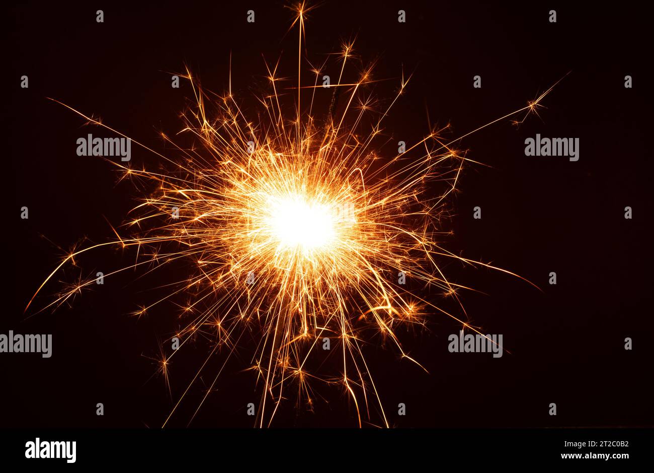 foto in mezzo allo sfondo nero, un brillante sparkler accende l'atmosfera, creando scintille di celebrazione che lasciano un sentiero che offre un'immagine suggestiva w. Foto Stock