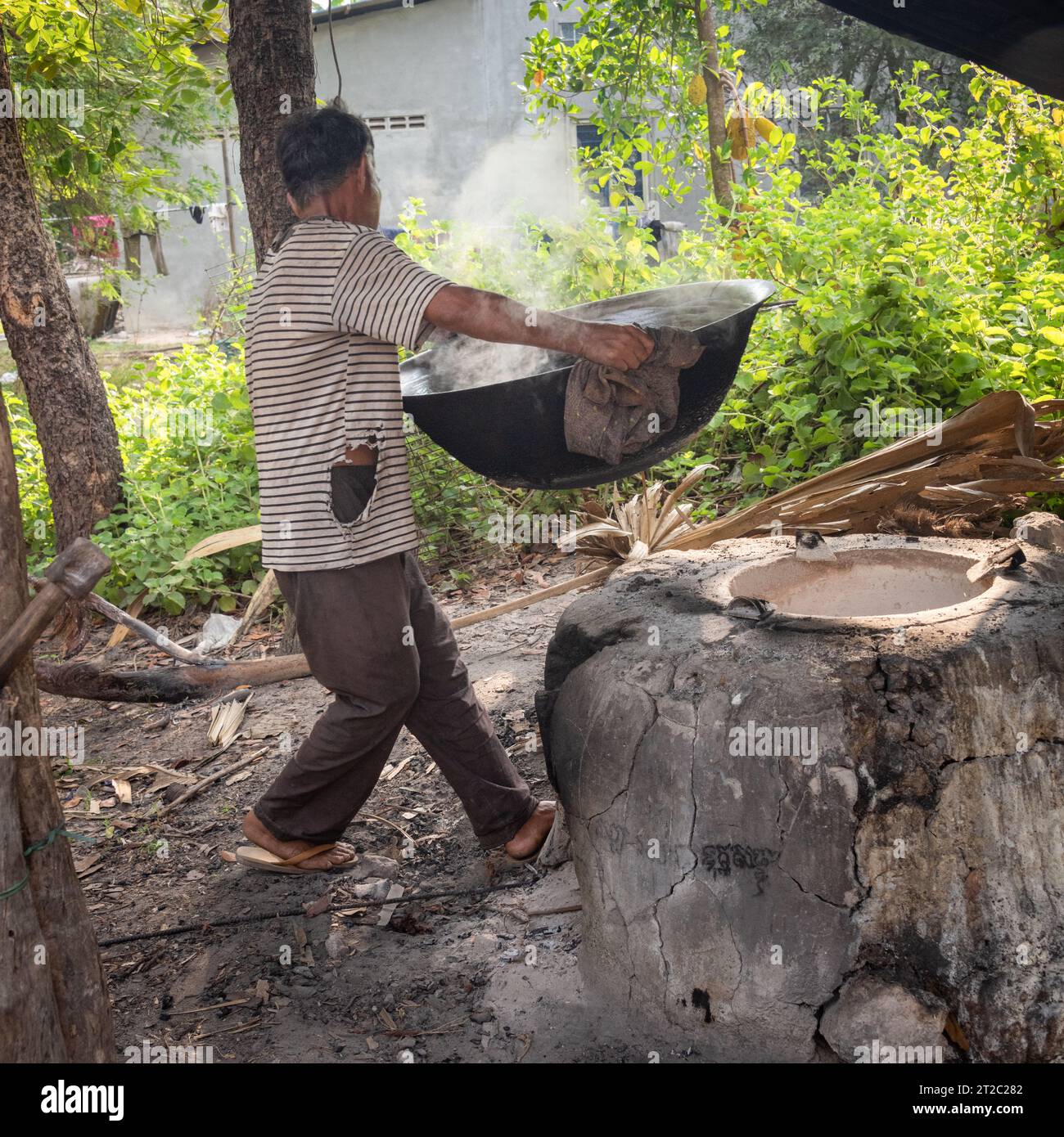 Uomo che fa zucchero di palma, Cambogia Foto Stock