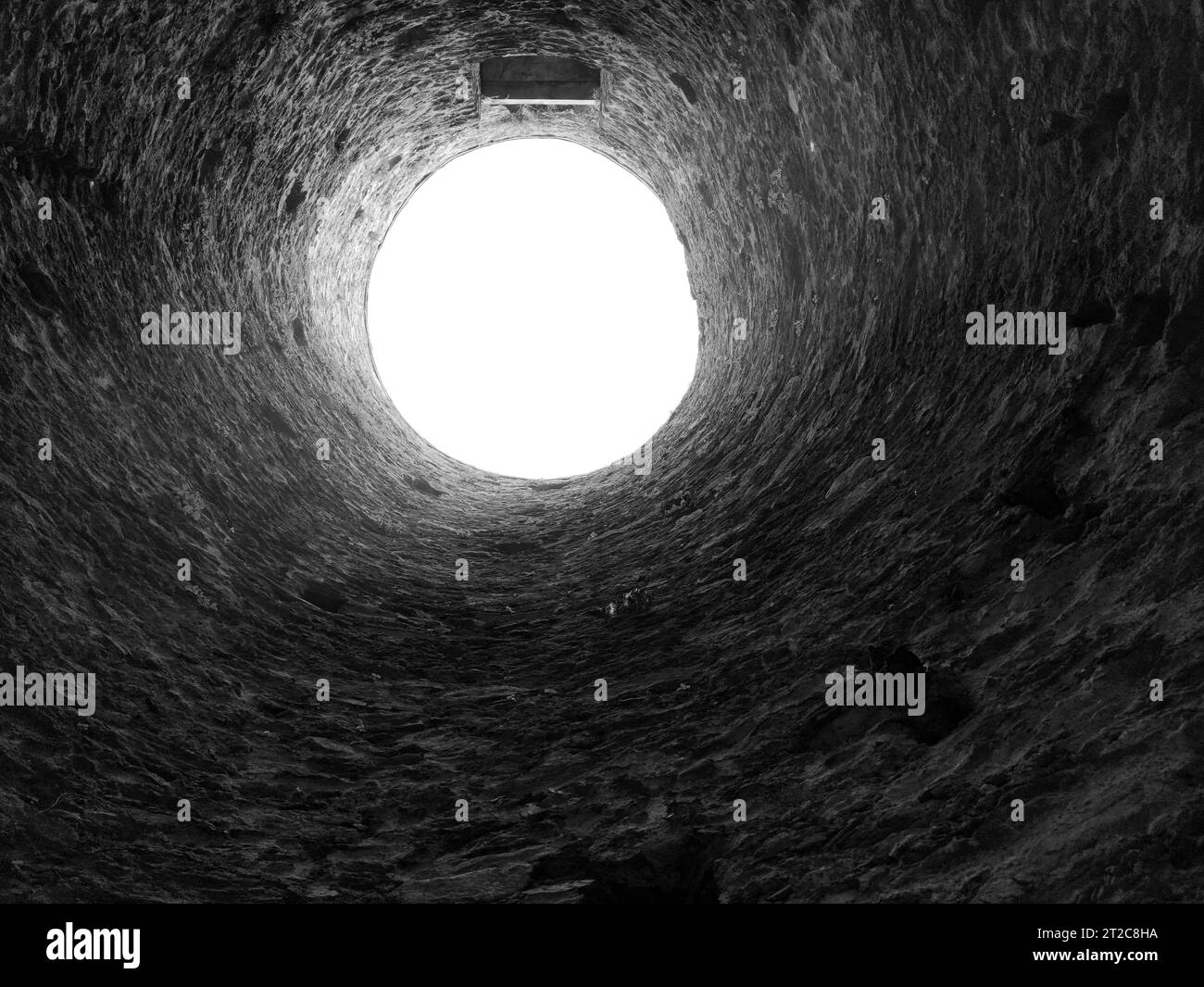 Buco di pozzo di pietra, costruzione vecchia dall'interno, cadere nel pozzo Foto Stock