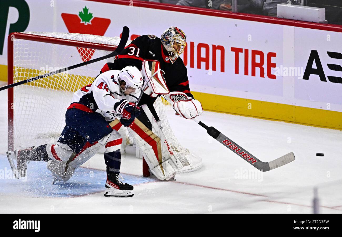 Ottawa Senators goaltender Anton Forsberg (31) passes the puck out of the reach of Washington Capitals center Matthew Phillips (45) during the third period of an NHL hockey game in Ottawa, Ontario, on Wednesday, Oct. 18, 2023. (Justin Tang/The Canadian Press via AP) Foto Stock