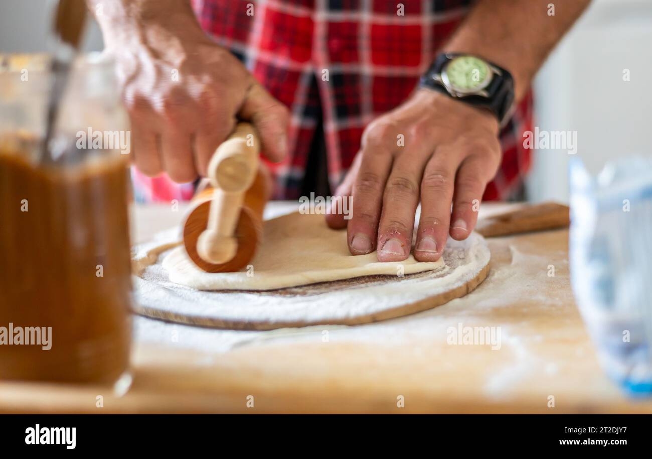 Dettaglio delle mani degli uomini che arrotolano l'impasto. Preparazione per la cottura della pasticceria tradizionale ceca. Piatti freschi fatti in casa Foto Stock