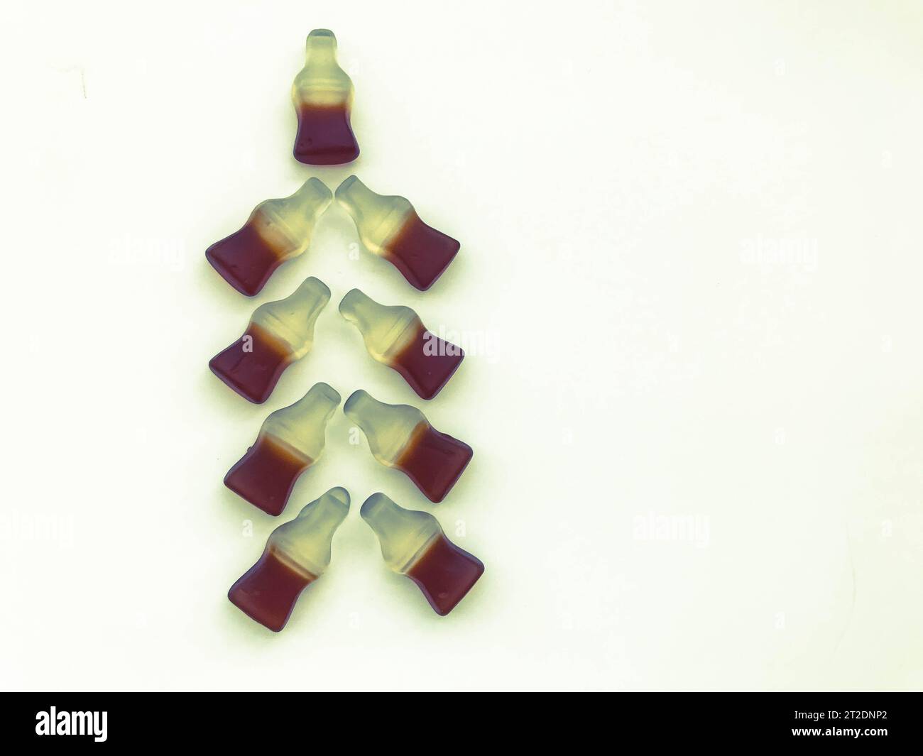 Albero di Natale realizzato con bottiglie gommose con limonata su sfondo bianco opaco. Albero di Natale insolito fatto di dolci. Un regalo di Natale. Foto Stock