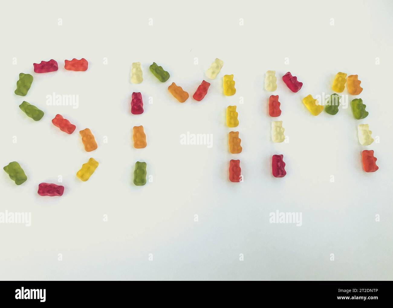lettera di orsi gommosi multicolori. Lettere S e M a base di caramelle gelatinose. Parola commestibile SMM. commercializzazione di gomme. brillanti e dolci orsi gommosi. Foto Stock