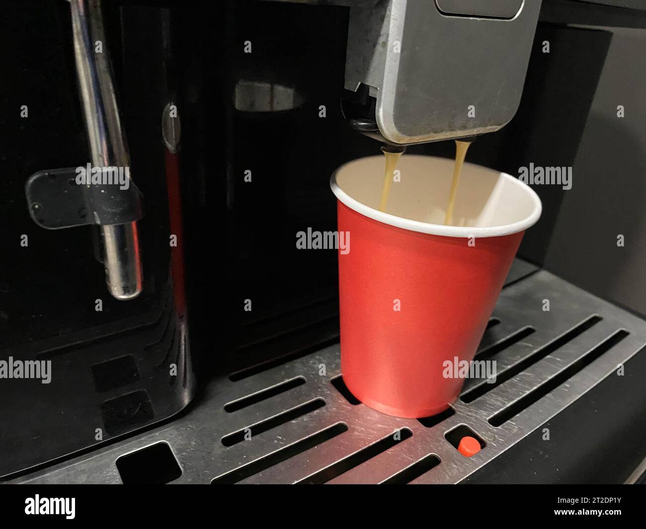 Preparazione dell'espresso dalla macchina per il caffè in una tazza di cartone da asporto. Messa a fuoco superficiale. Foto Stock