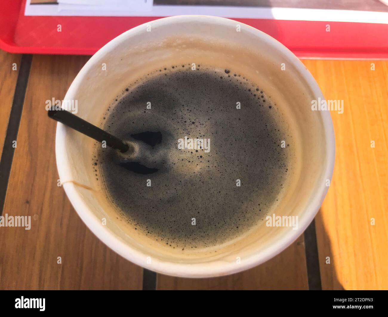 Una tazza di caffè veloce nero caldo e naturale dal fast food in un bicchiere di carta con cannucce. Foto Stock