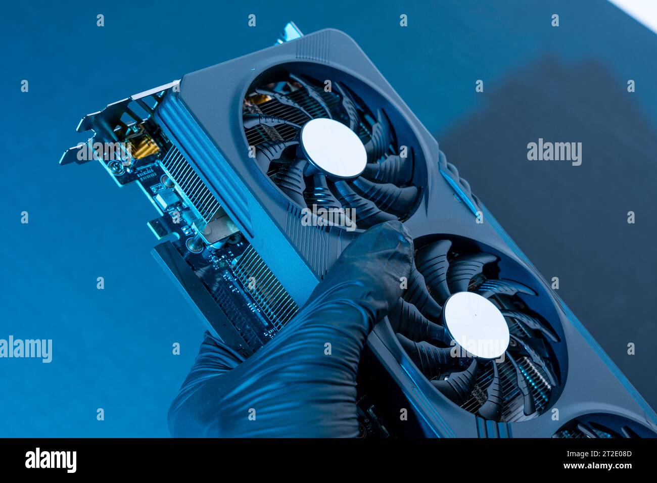 la mano di un tecnico informatico contiene una potente e moderna scheda per videogiochi per un computer con tre fan. Il concetto di hardware per PC. Video car di gioco Foto Stock