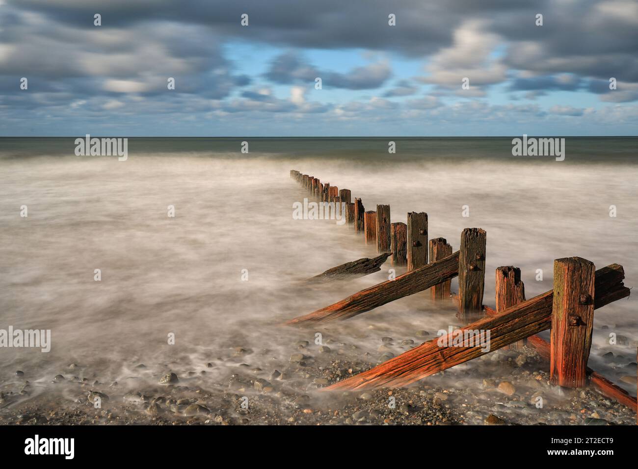 Groynes in legno spezzano l'acqua di Barmouth, Galles Foto Stock