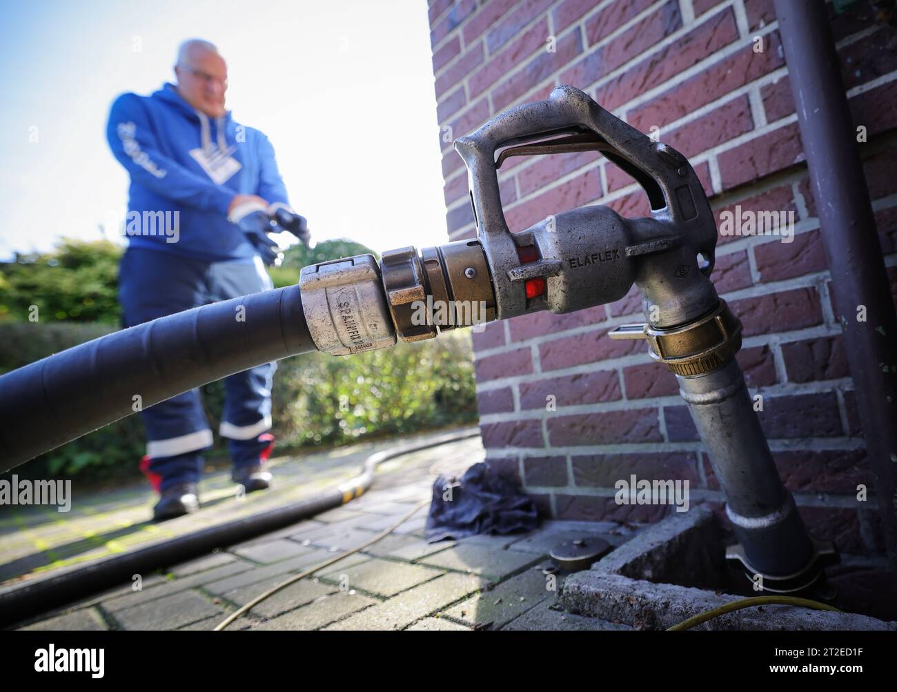 18 ottobre 2023, Schleswig-Holstein, Bad Brahmstedt: Un tubo flessibile con ugello è fissato al collo del bocchettone di rifornimento per la consegna dell'olio combustibile a un cliente in una casa a famiglia. Foto: Christian Charisius/dpa Foto Stock