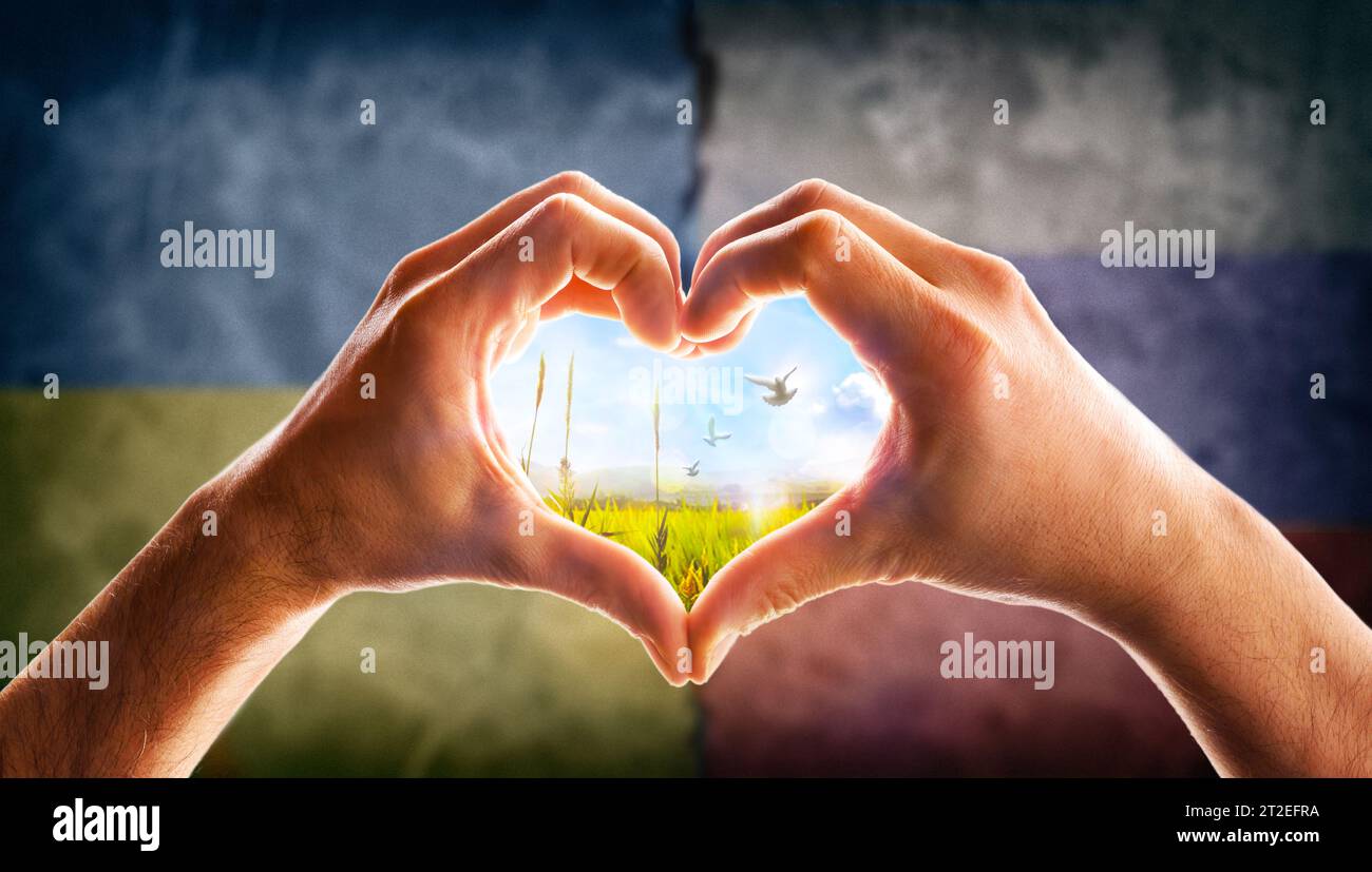 Concetto di riconciliazione e solidarietà con la società Ucraina e Russia a causa del conflitto armato con le mani che formano un cuore con spirito paesaggistico Foto Stock