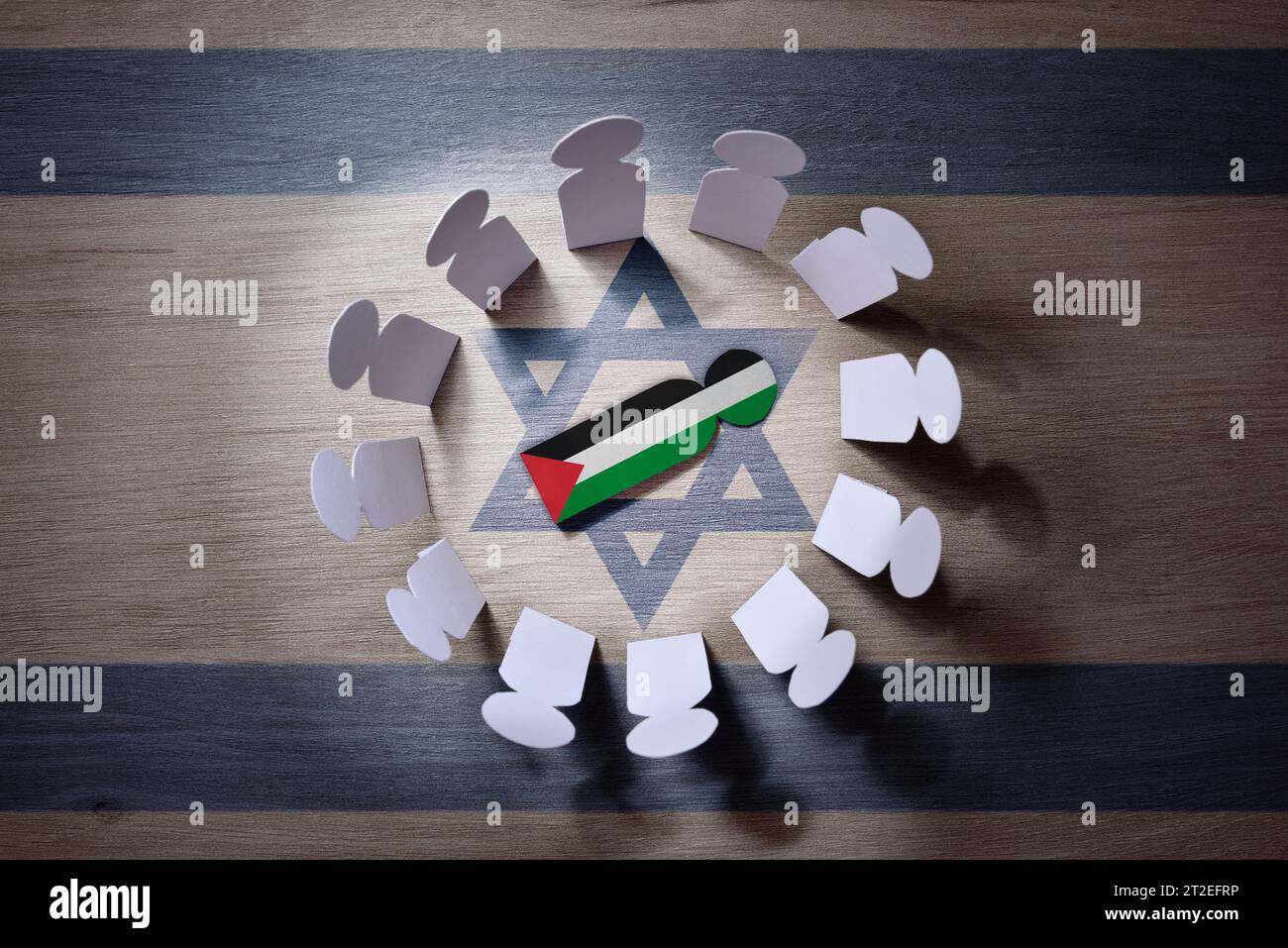 Concetto di radunare i palestinesi da parte delle forze israeliane con ritagli di uomini israeliani attorno a ritagli di uomo palestinese al centro. Vista dall'alto. Foto Stock