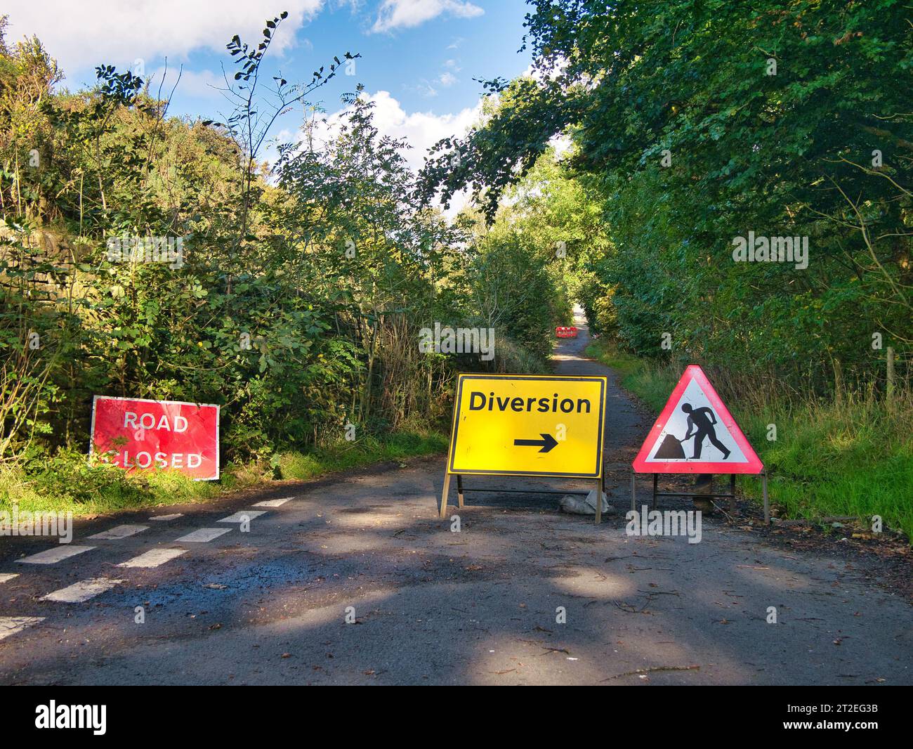 I cartelli segnalano che una strada di campagna è chiusa e che è presente una deviazione. Preso nel Derbyshire, Regno Unito, a fine estate. Foto Stock