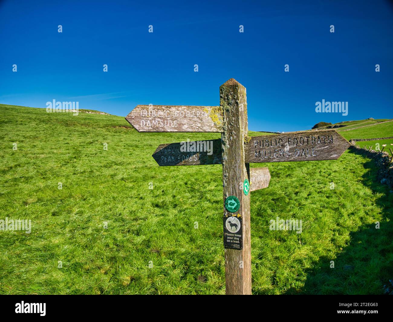 Le impronte digitali in legno esposte agli agenti atmosferici indicano la strada per tre diversi luoghi nel Peak District nel Derbyshire, Regno Unito. Preso in una giornata di sole con un cielo blu. Foto Stock