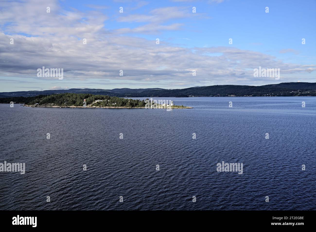 Vista panoramica del fiordo di Oslofjord con foreste e paesaggi montani sulla costa, con campana di Søndre Langåra Fog sull'isola di Langåra, Norvegia Foto Stock
