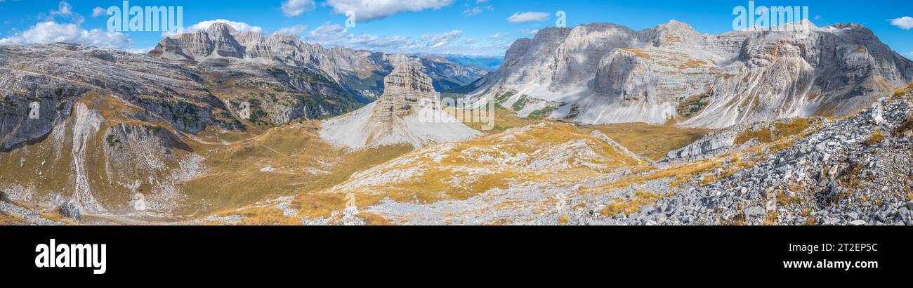 Vista panoramica dell'alta valle alpina con alta torre monolitica in arenaria nelle Dolomiti di Brenta Foto Stock