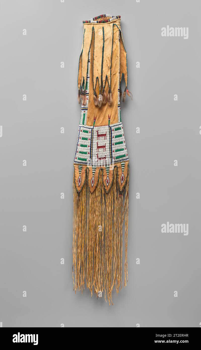 Sacco di tabacco Southern Cheyenne, nativo americano CA. 1875 sacchetti riccamente adornati come questo esempio sono stati creati dalle donne per i loro familiari maschi per portare pipa a gambo lungo e tabacco, che hanno usato nelle cerimonie spirituali. Qui, una borsa ad alto contrasto presenta disegni di animali e perline geometriche. Le strisce in pelle biforcate con perline blu sono appese all'apertura del sacchetto e si riflettono nelle linguette arrotondate e nelle frange a fessura sottostanti. Tinkler a cono in metallo decorati con capelli rifiniti da criniera di cavallo e tinti di rosso punteggiano le linguette e le strisce. Visualizza altro. Sacco di tabacco. Cheye meridionale Foto Stock