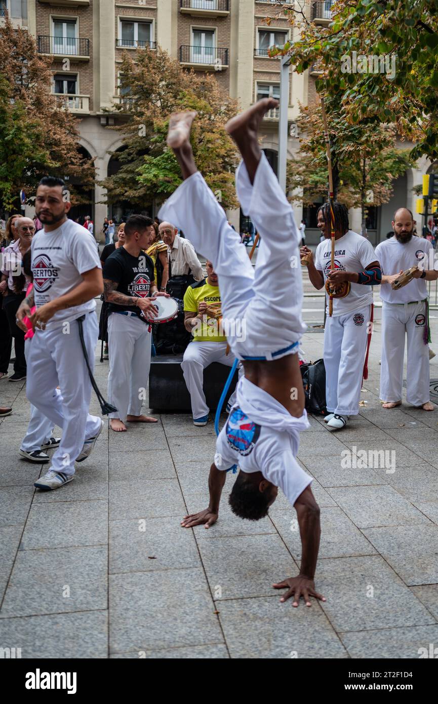 I membri di Mestre Branco Capoeira Escola manifestano in strada durante le feste di El Pilar a Saragozza, Aragona, Spagna Foto Stock