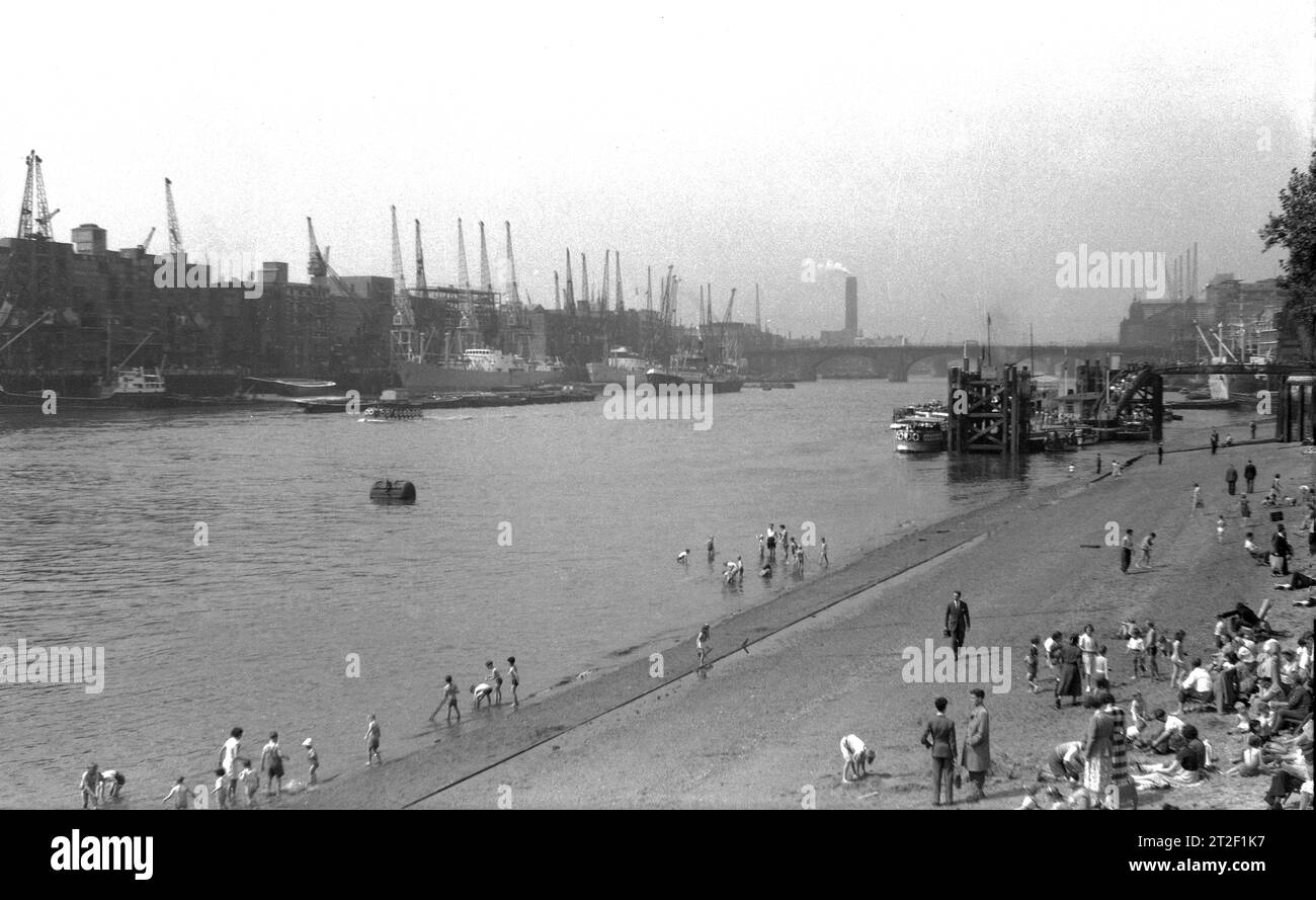 Anni '1950, storico, gente sulla Tower Beach, una sezione della costa del fiume Tamigi, Londra, Inghilterra, Regno Unito. Queste sezioni di spiagge mareali, note anche come spiagge urbane, sono coperte d'acqua durante l'alta marea. Aperta al pubblico nel 1934, Tower Beach chiuse nel 1971. Foto Stock