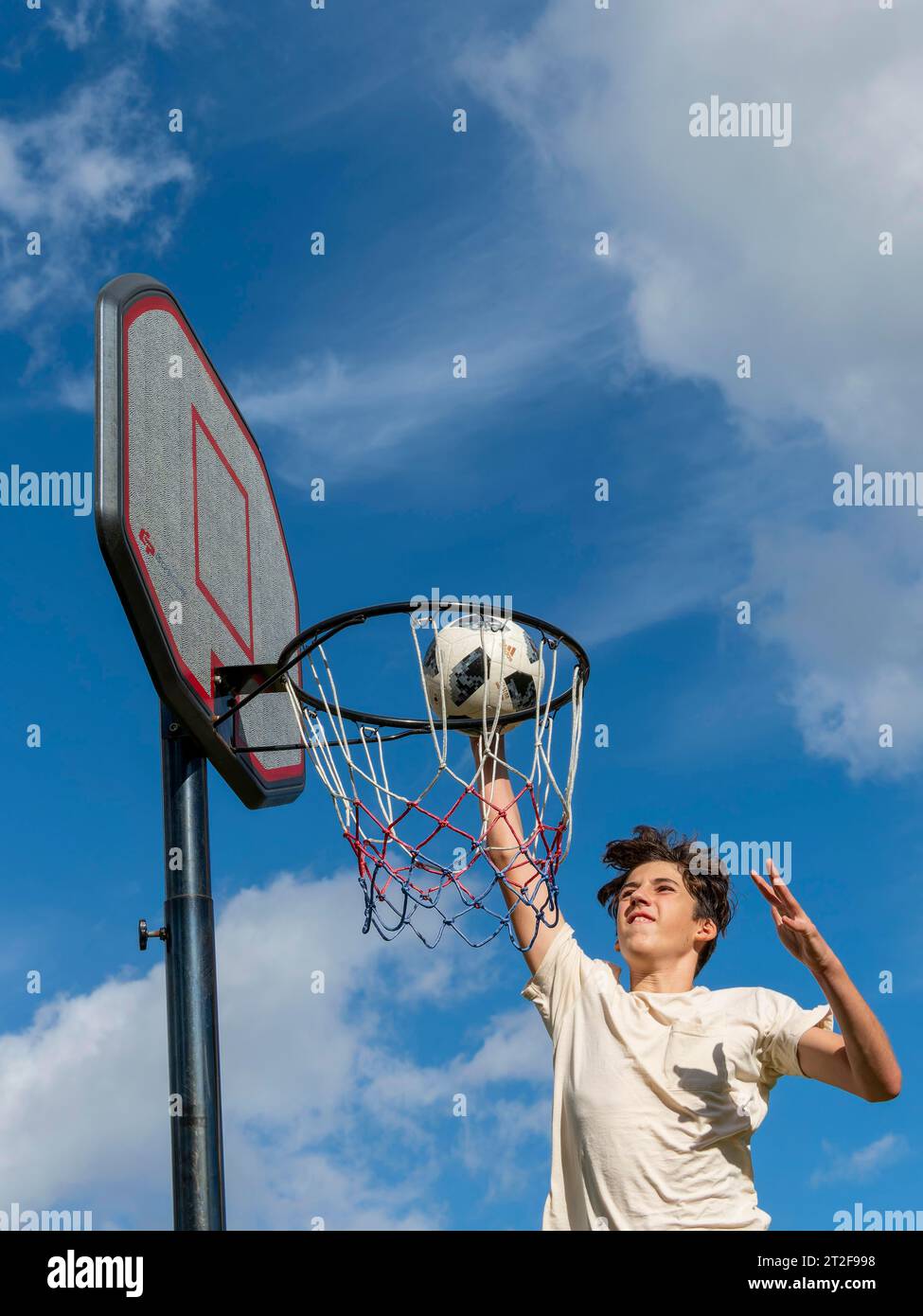 Pallacanestro salto con la palla al cestino e alla rete, ragazzo 14 anni, attività sportiva con bambini, Germania Foto Stock