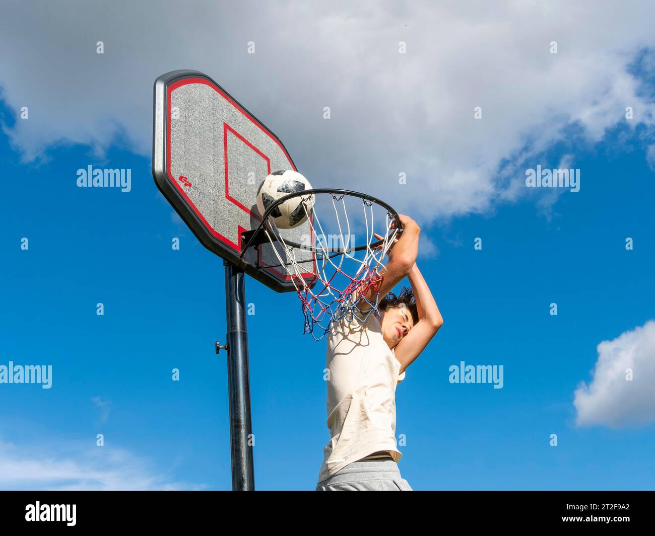 Pallacanestro salto con la palla al cestino e alla rete, ragazzo 14 anni, attività sportiva con bambini, Germania Foto Stock